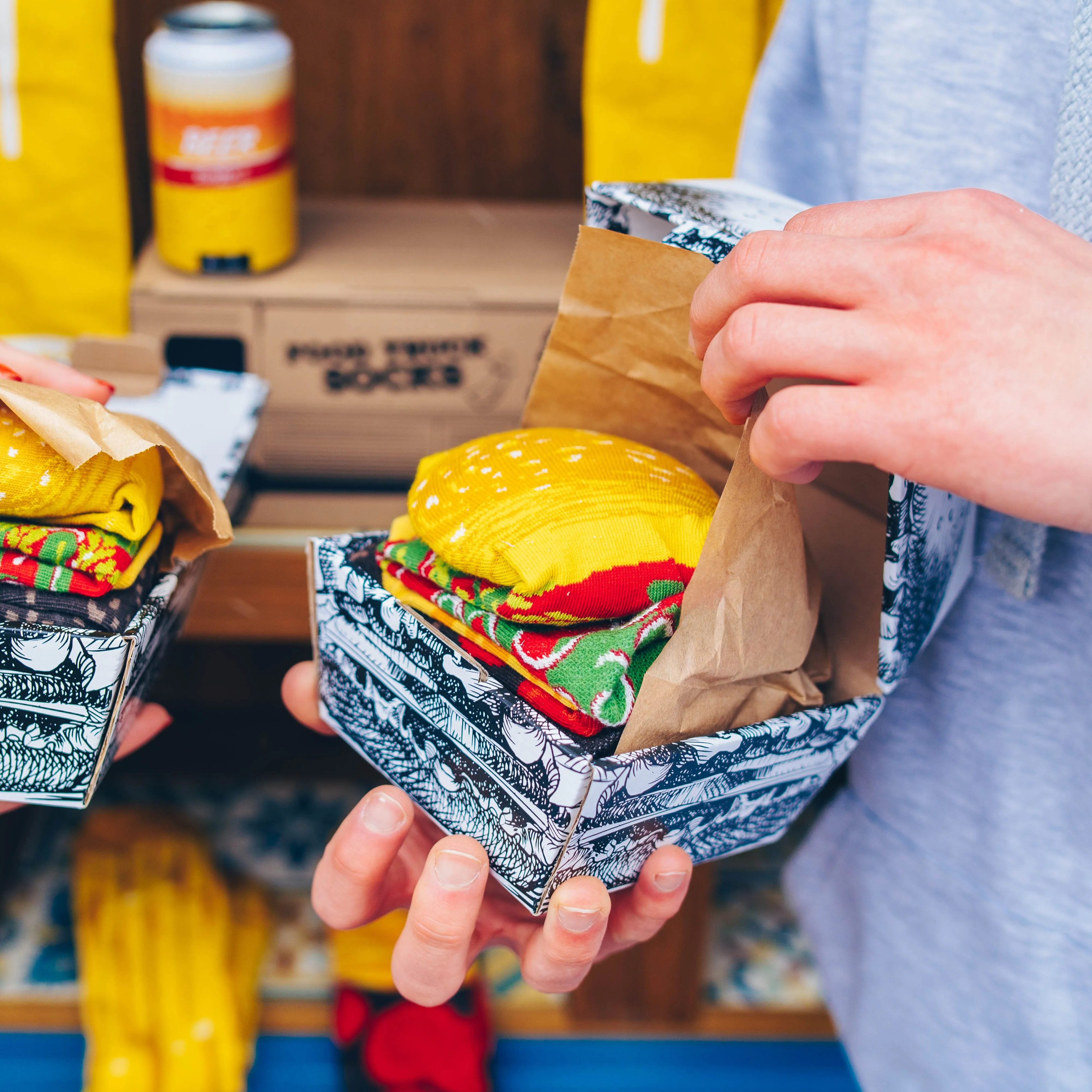 Mężczyzna trzymający w ręku skarpetki burger Rainbow Socks